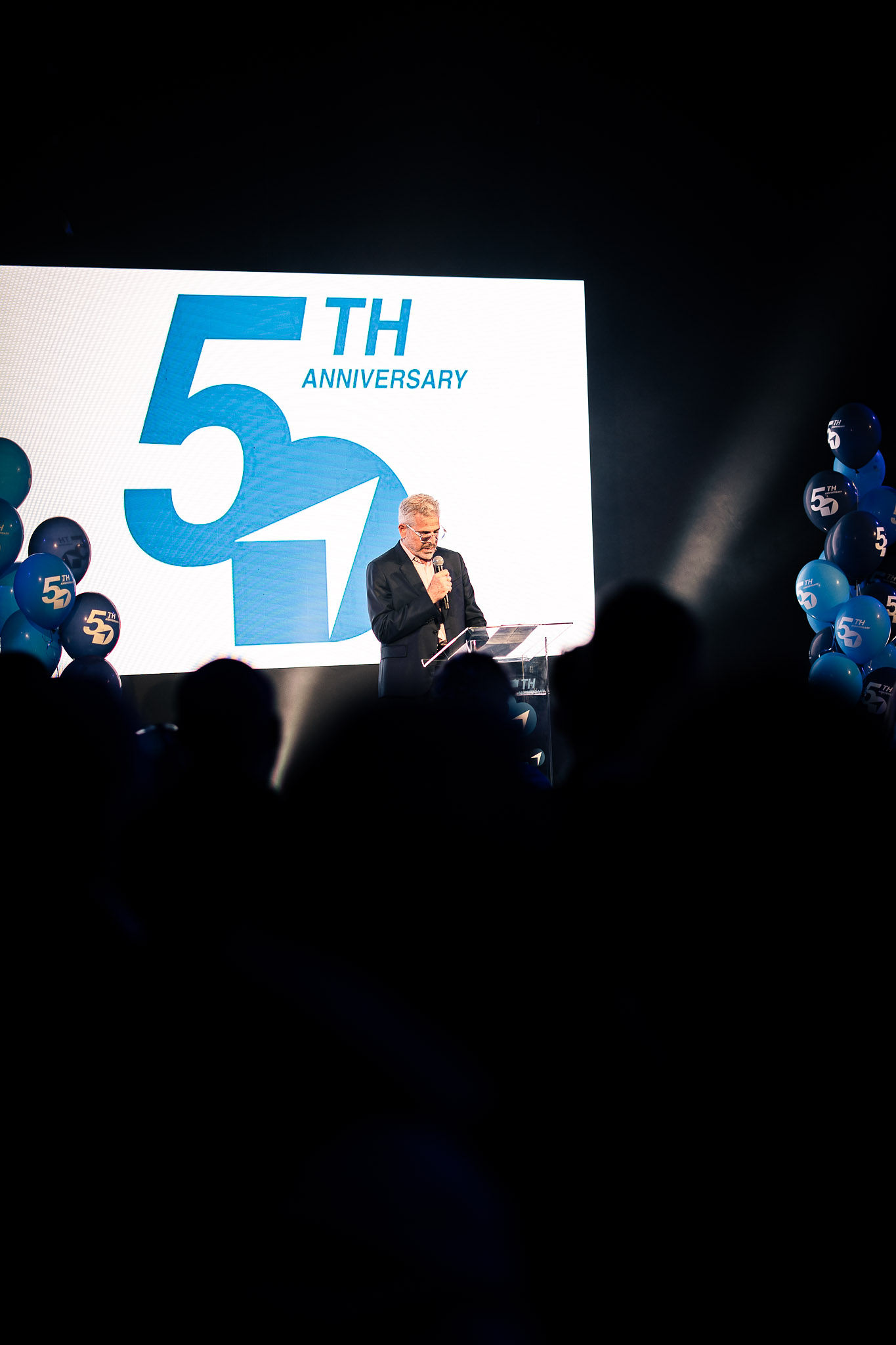 Gala anniversary dinner corporate Belgium, seated banquet with stage lighting · INNOV'events
