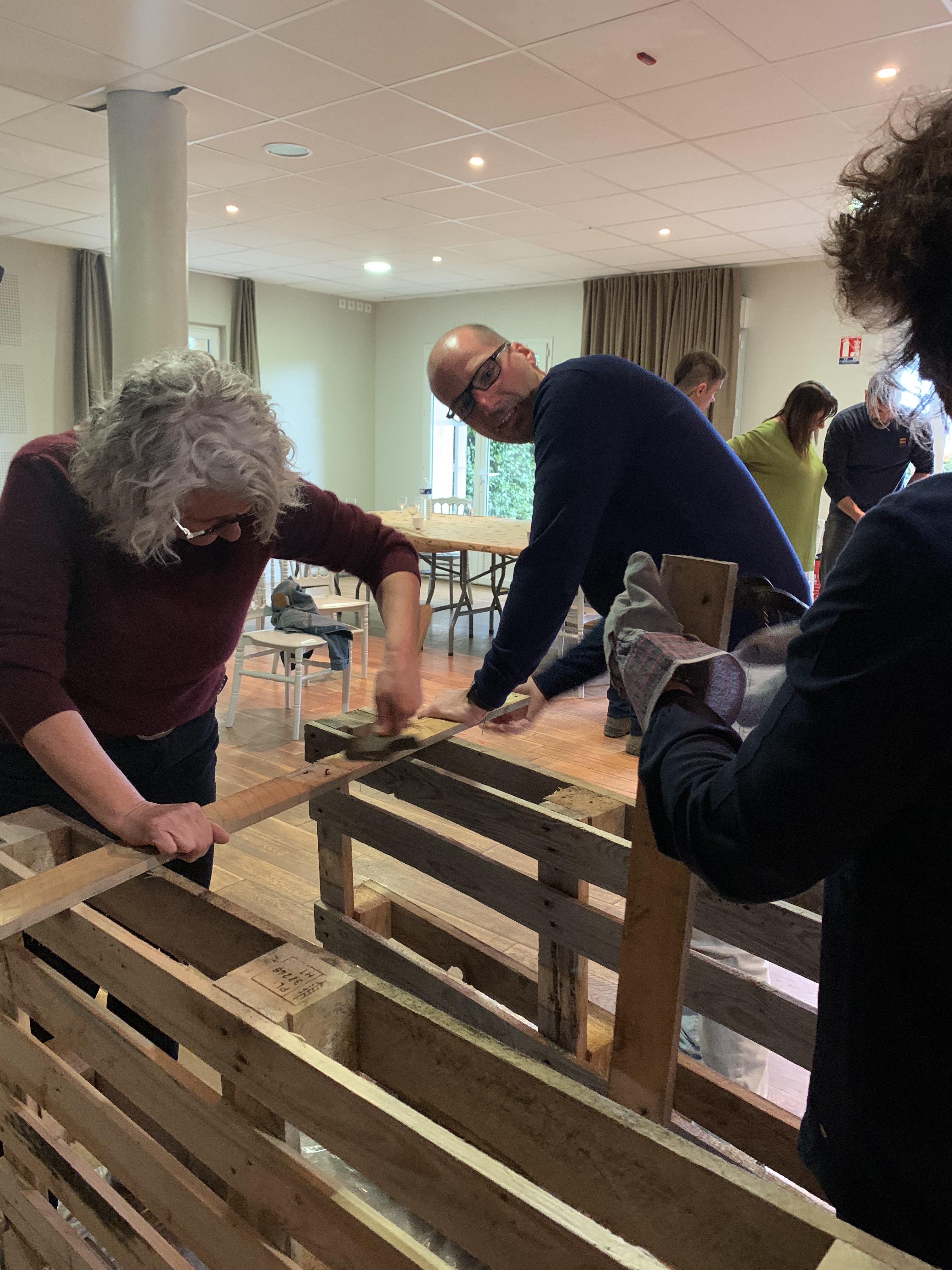 Atelier construction complet création de baby-foot Bruxelles équipes assemblant les tiges · INNOV'events