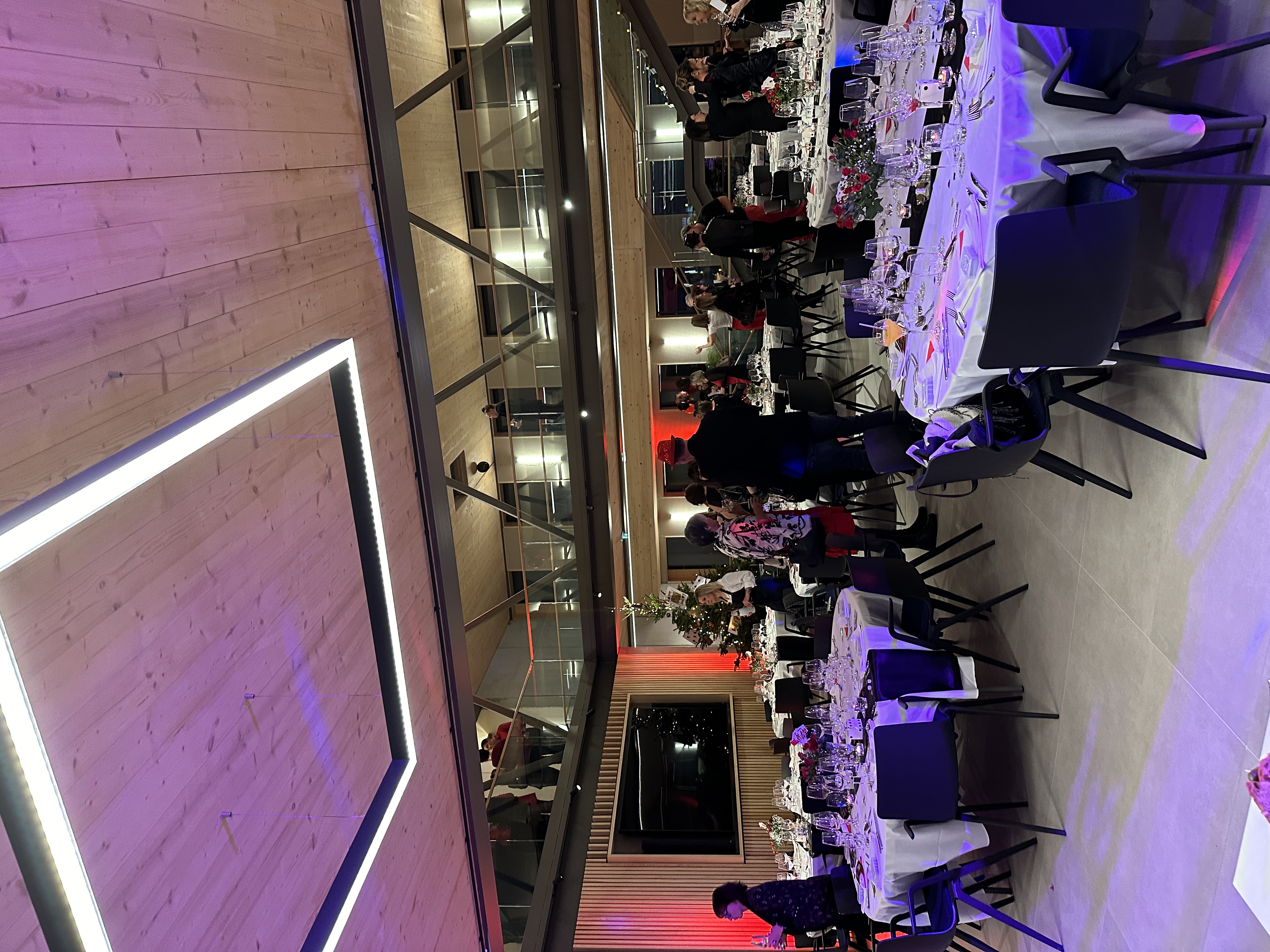 Gala assis Liège grande salle décorée lumières tamisées et fleurs de table · INNOV'events organisation d'événements