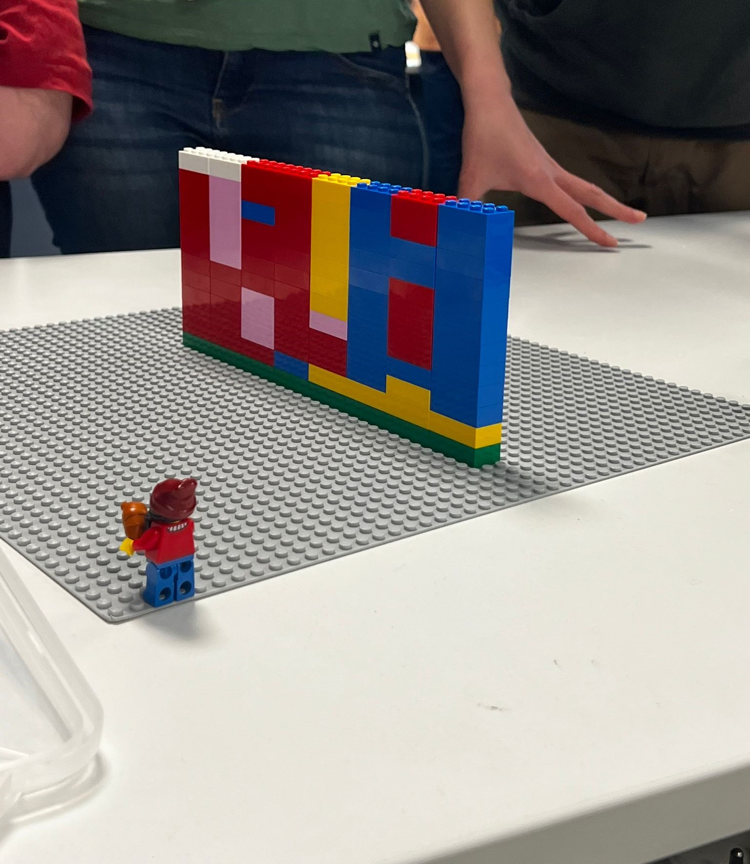 LEGO challenge Antwerpen team bouwt aan tafel met Eilandje-pakhuis op achtergrond · INNOV'events