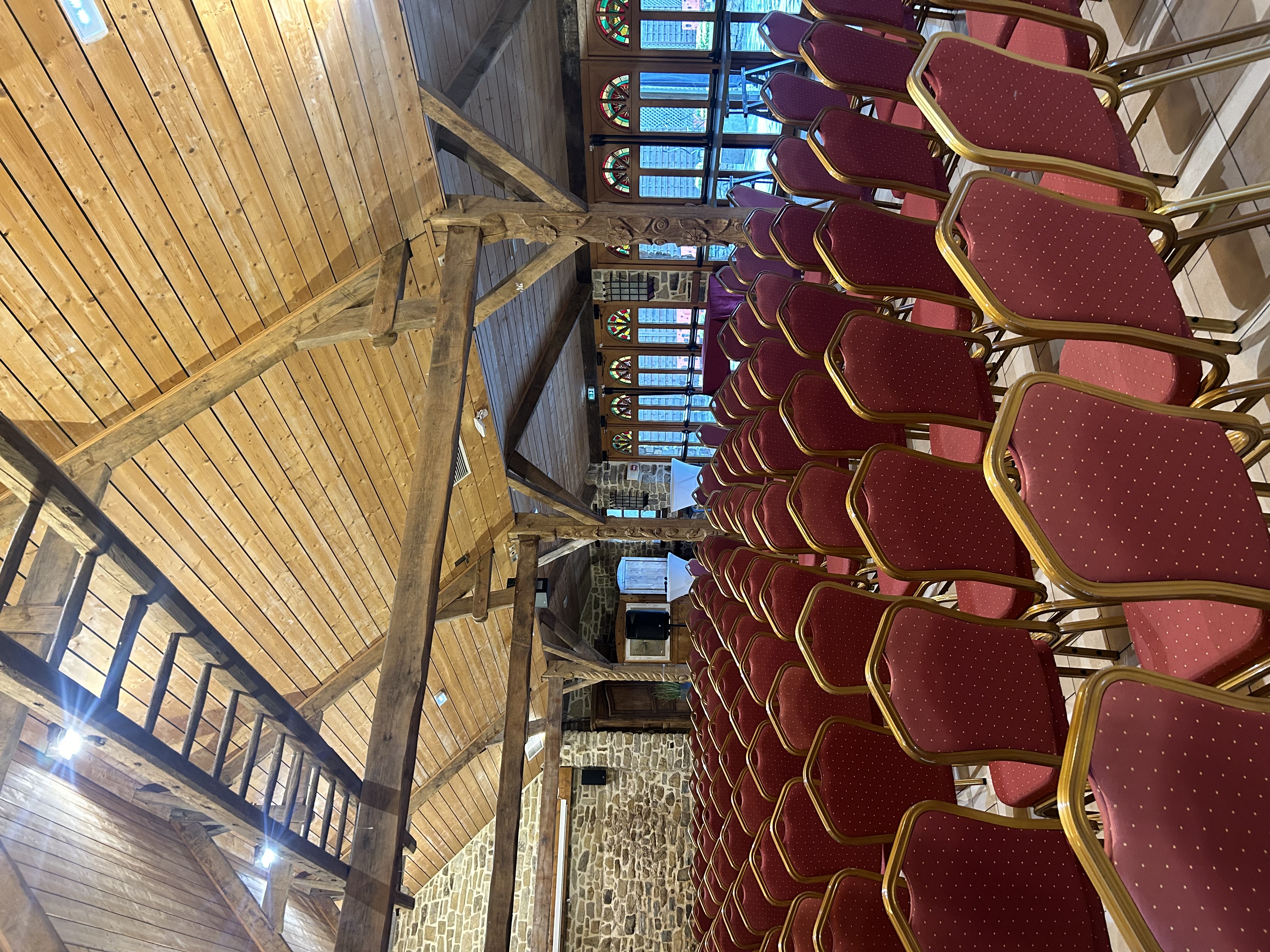 Seminar rental België plenaire zaal met sprekers en projectiescherm · INNOV'events