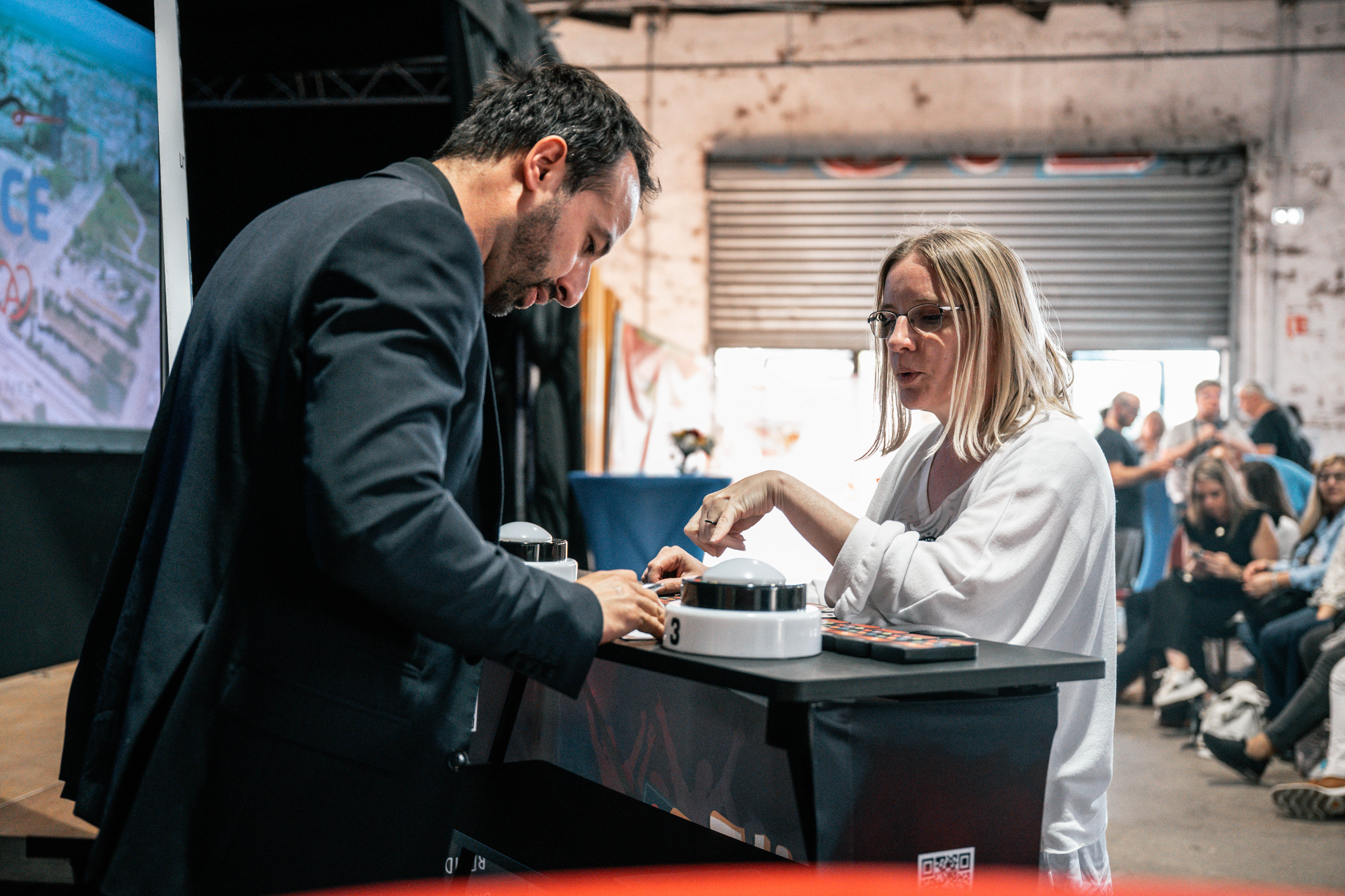Hybride algemene vergadering Antwerpen livestream scherm en aanwezige deelnemers · INNOV'events