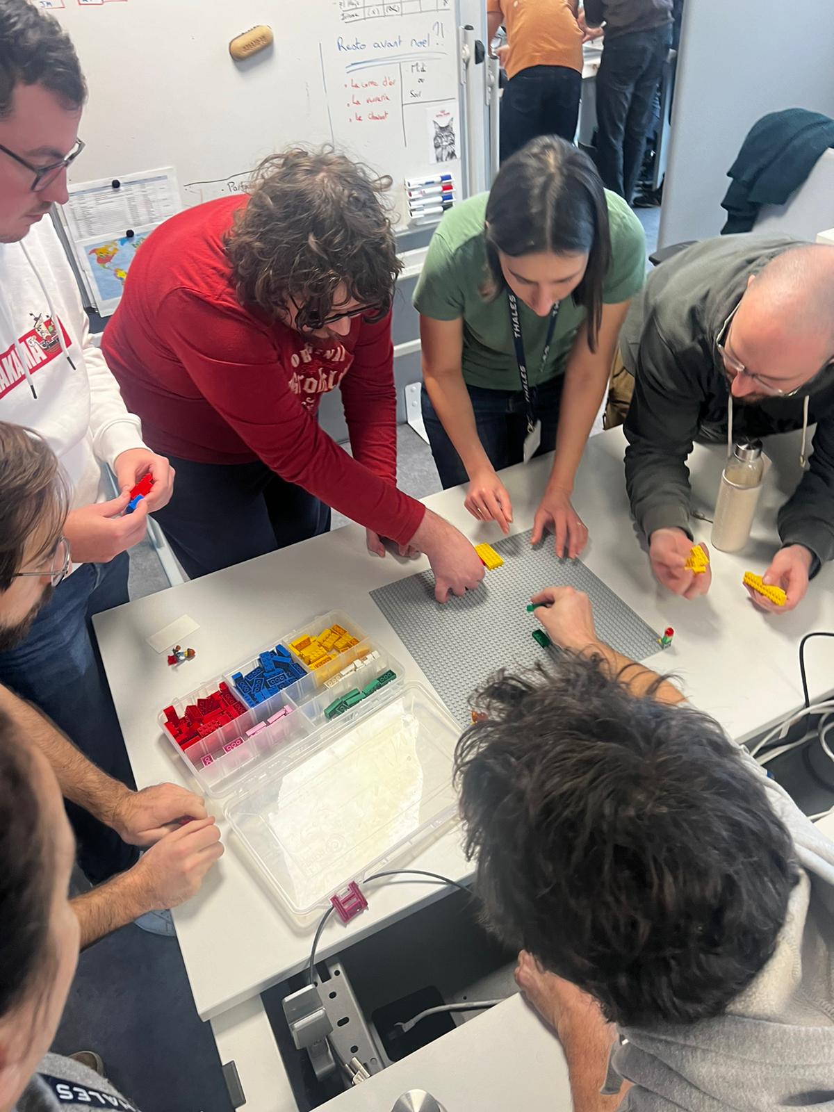 Challenge LEGO soirée Liège participants détendus briques colorées éclairage tamisé · INNOV'events