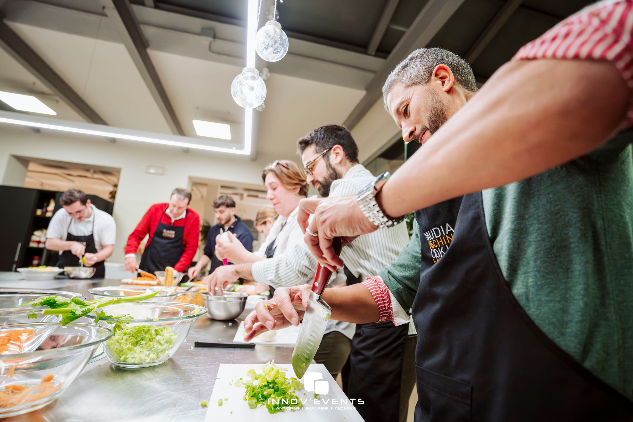 MasterChef kookworkshop Brussel chef instrueert groep in lichte kookstudio · INNOV'events